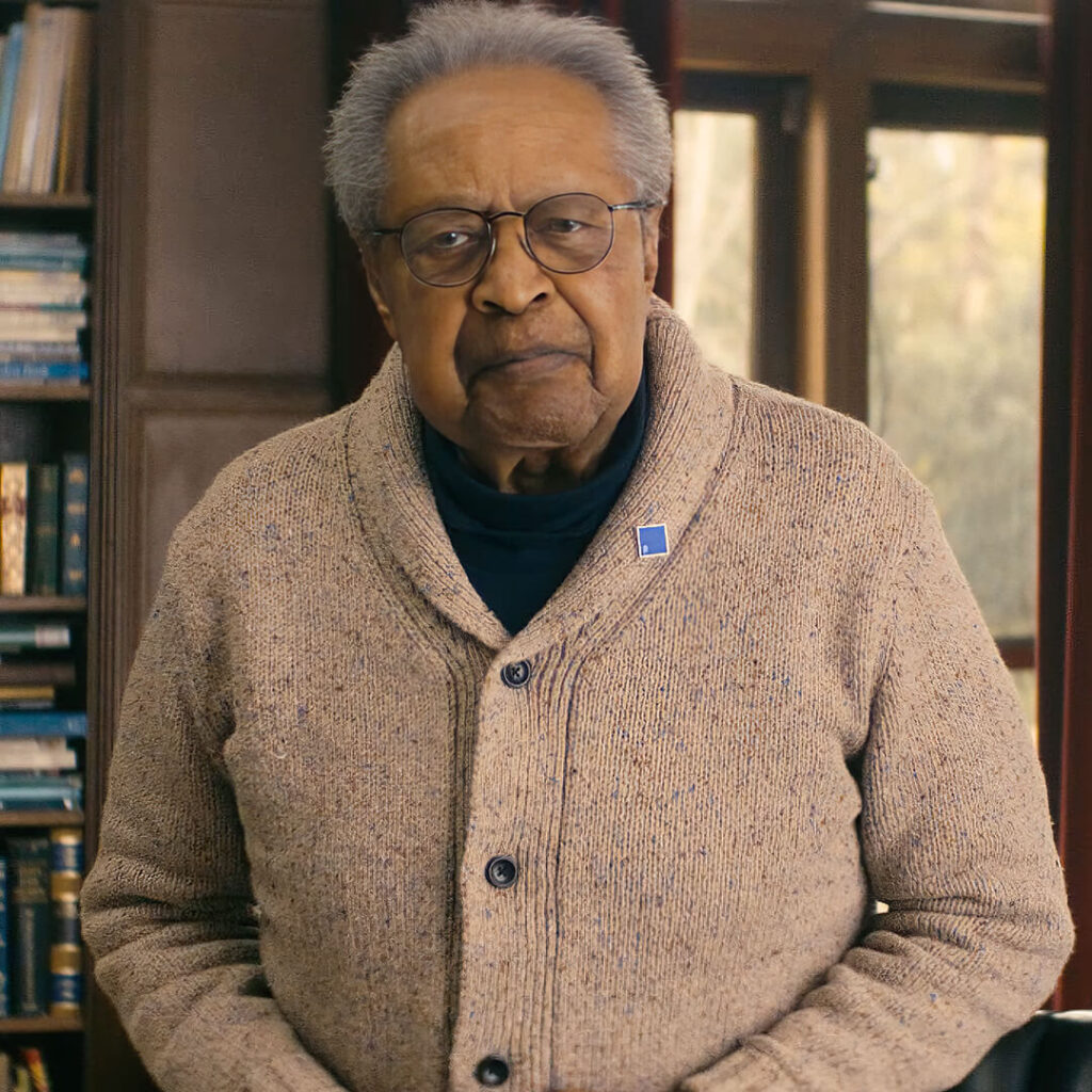 Clarence B. Jones wearing a blue square pin in support of the fight against hate.